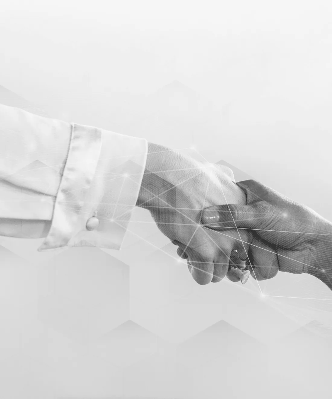 Two people shaking hands over a signed agreement